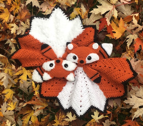 Two crocheted lovey foxes